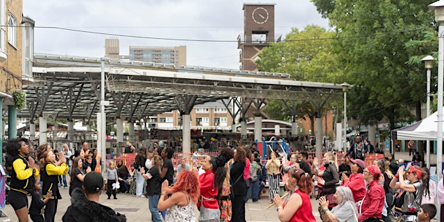 Group of people dancing in a market square.